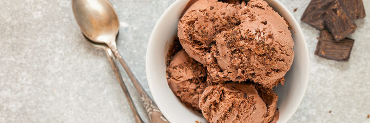 Chocolate ice cream with a bowl on a table. Summer dessert. Selective focus. Copy space. Flat lay.