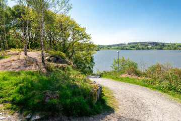 Fototapeta na wymiar A gravel walking path running downhill to Halandsvatnet lake, Stavanger, Norway, May 2018