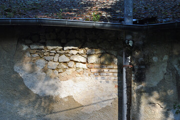 Old Plastered Wall with Exposed Stone on Old Building