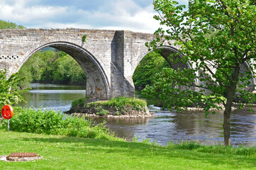 Fototapeta na wymiar View of Ancient Stone Bridge and River on Sunny Day 