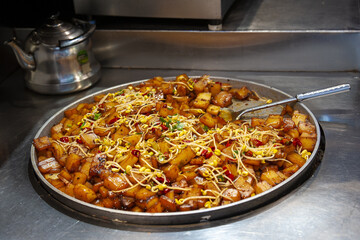 Goulash, beef stew in cast iron pan on dark background, top view, close up. China. Xi'an.
