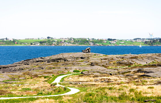 A footpath running along the coast and Brutt Lenke monument in Kvernevik suburb, Stavanger, Norway, May 2018