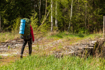 A tourist, a traveler with a backpack on his back, walks along a dilapidated bridge, a crossing.
