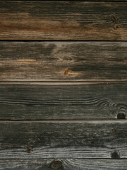 The background texture of the wall is made of brown old wooden boards. Close-up.
