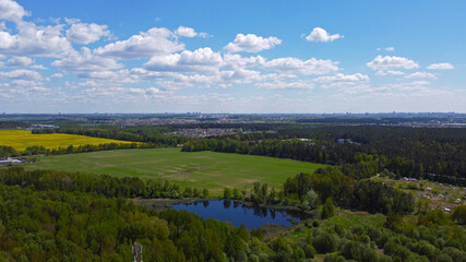 Fototapeta na wymiar Aerial view of a green rural landscape with forests and meadows