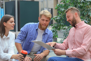Obraz premium Young colleagues in smart casual wear working while spending time in the office.