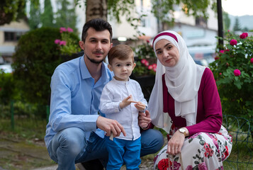 Portrait of a happy young muslim family in the summer park.