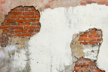 Old red brick wall with white stucco, paint and cracks.