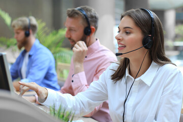 Attractive positive young businesspeople and colleagues in a call center office.