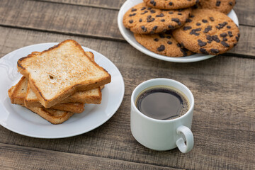 Cup of black coffee, toast and cookies