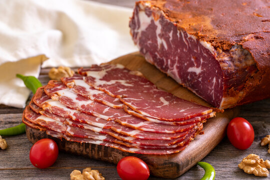 Turkish pastrami. Bacon made from ribeye meat. Beef pastrami sliced Pastirma or Turkish pastrami. Close-up.