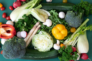 Close-up, different bright vegetables on a green background, flat lay.