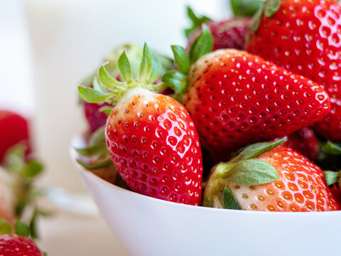 close-up photo of a delicious stawberry in a white bowl. healthy food