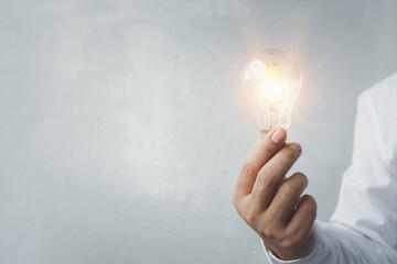 hand holding light bulb. idea concept with innovation and inspiration, ideas of new ideas with...