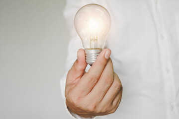 hand holding light bulb. idea concept with innovation and inspiration, ideas of new ideas with innovative technology and creativity. ideas creativity concept holding light bulb.	
