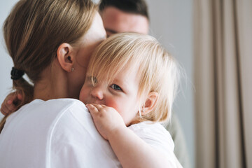 Close up portrait of family father young man and mother with baby girl little daughter near window at home