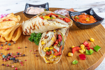 Turkish cuisine chicken wrap. Grilled chicken sandwich wrap with lettuce, red pepper and french...