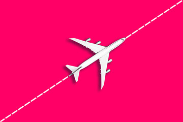 Flat lay design of travel concept with plane on pink diagonal dotted line