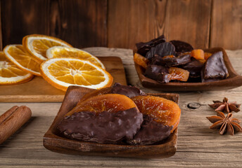 Candied oranges with chocolate. Dryed oranges and cinnamon.