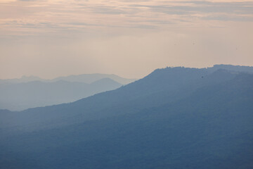 Beautiful nature, verdant trees with bright sky. and a tall white windmill Producing electricity in Thailand