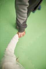 children hold hands, on a green background, close-up of children's hands together