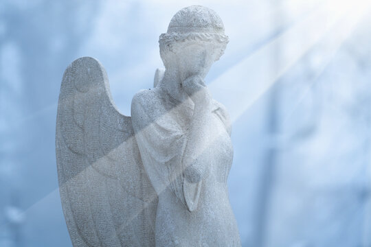 Guardian angel. Ancient stone statue. Horizontal image.