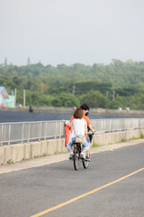 Obraz premium people riding bicycles, playing and exercising on vacation On the road and see the beautiful nature Thailand Dates 28-5-2022