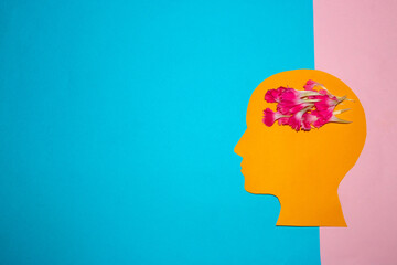 orange head with a brain of pink petals on a blue-pink background, creative thinking, creating ideas in the head