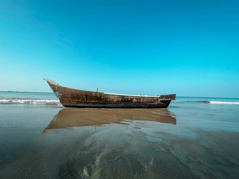Indian fishing boat on beach of Indian Ocean in misty midday 