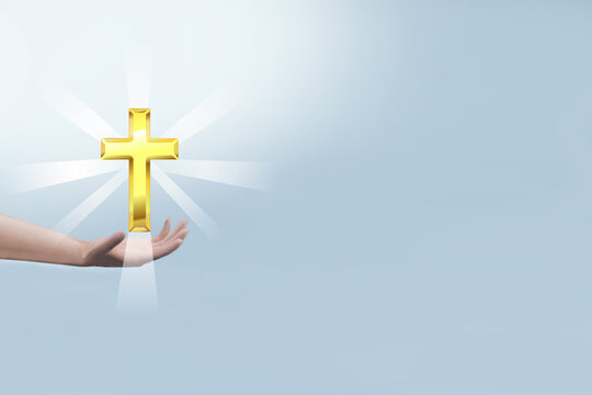 Hand holding Christian Cross with light ray on blue background. Religion concept. 3D rendering image.