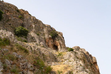 Overgrown  with small crooked trees, grass and bushes, the slope of Mount Arbel, located on the shores of Lake Kinneret - the Sea of Galilee, near the city of Tiberias, in northern Israel.