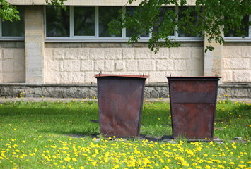 Obraz premium Two rusty metal dumpsters in the yard