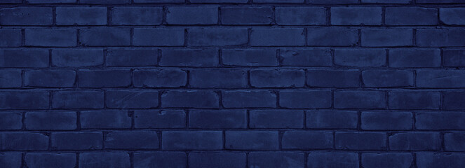 Navy blue old rough brick wall wide texture. Exterior brickwork close-up dark backdrop. Gloomy grunge indigo color abstract textured widescreen background