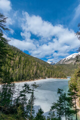 frozen mountain lake in the forest during spring (Blindsee, Tyrol, Austria)