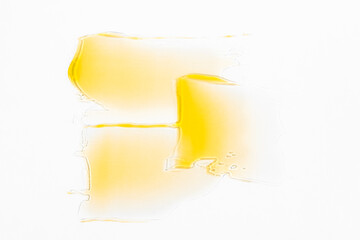 Smears of a cosmetic product in orange color on a light gray background top view.