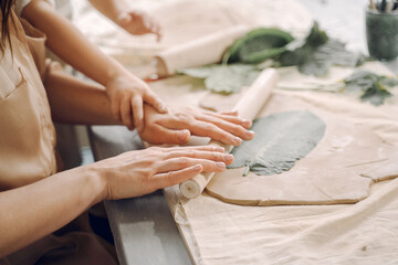 Portrait of mother and little girl shaping clay together