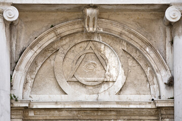 Old architecture with, all seeing eye relief, mason symbol above entrance to saint magdeleine...