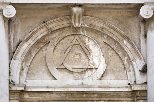 Old architecture with, all seeing eye relief, mason symbol above entrance to saint magdeleine church in Vience Italy.