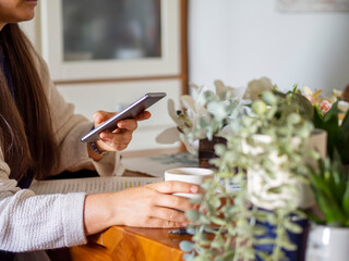 Unrecognizable woman browsing social media in the morning drinking coffee and planning the workday....