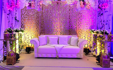 An elegantly staged traditional moroccan style wedding with large sofa for the wedding couple to...