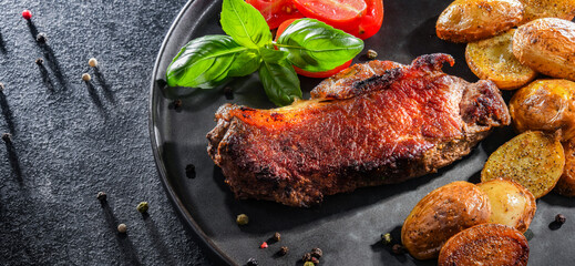 Pan-fried beef steak with fried potatoes and cherry tomatoes