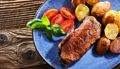 Pan-fried beef steak with fried potatoes and cherry tomatoes