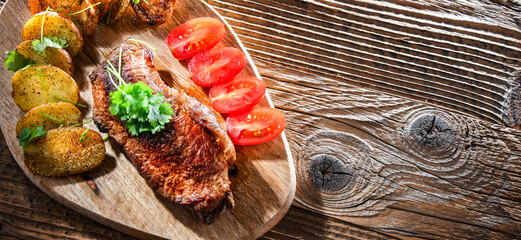 Pan-fried beef steak with fried potatoes and cherry tomatoes