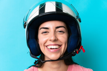 Young caucasian woman with a motorcycle helmet isolated on blue background