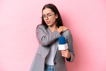 Young caucasian tv presenter woman isolated on pink background suffering from pain in shoulder for...