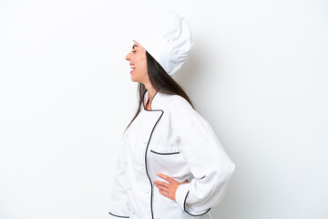 Young chef woman over white background laughing in lateral position