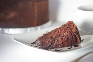 Slice of homemade chocolate cake decorated with syrup