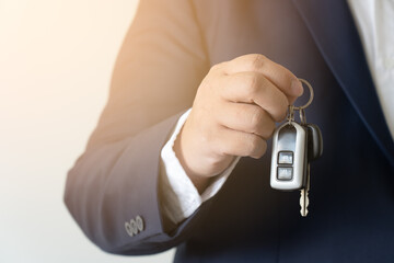 Businessman holding car key concept of buy new vehicle car. Giving car key to customer or car rental service.