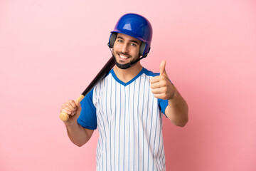 Baseball player with helmet and bat isolated on pink background with thumbs up because something...