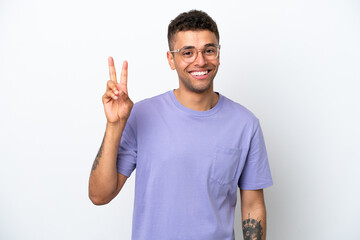 Fototapeta premium Young caucasian Brazilian man isolated on white background smiling and showing victory sign